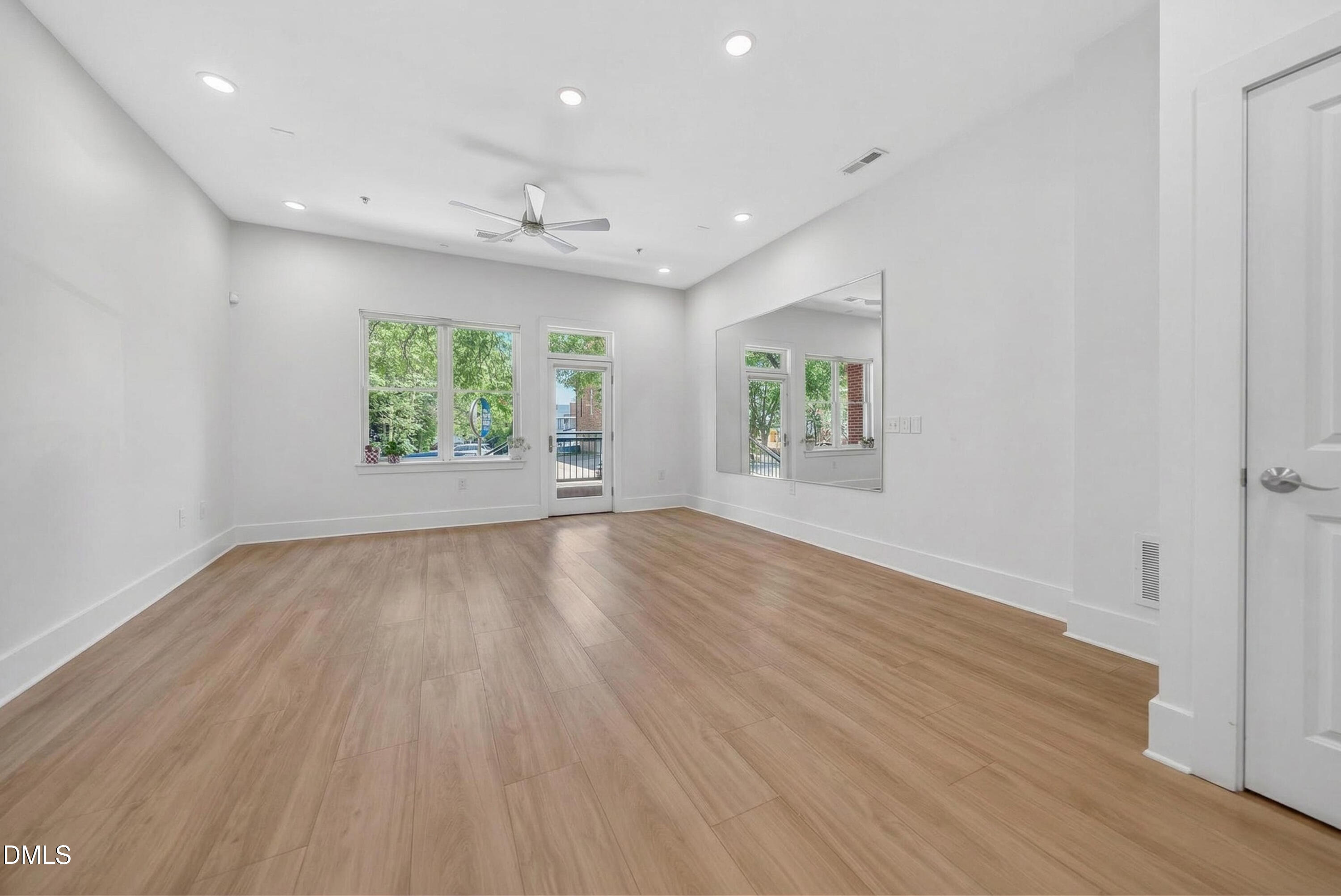 444 South Blount Street, Unit 111 Raleigh, NC 27601 - Photo 3 of 40 an empty room with wooden floor and windows