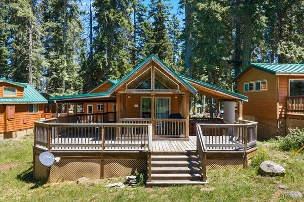 a view of a house with a deck and a yard