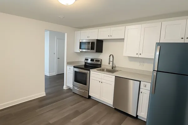 a kitchen with white cabinets and white appliances