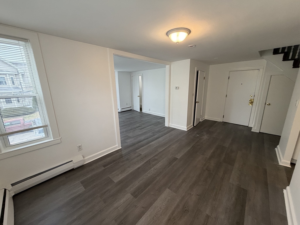 149 Adams Street, Unit 149 Waltham, MA 02453 - Photo 5 of 12 an empty room with wooden floor and windows