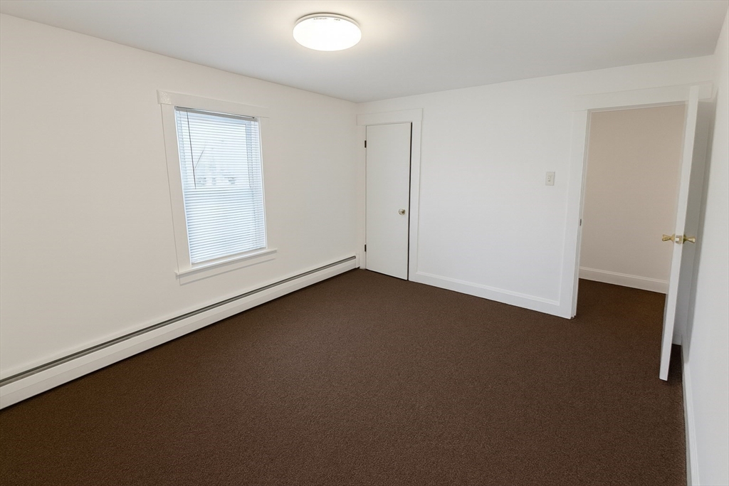 149 Adams Street, Unit 149 Waltham, MA 02453 - Photo 8 of 12 an empty room with a door