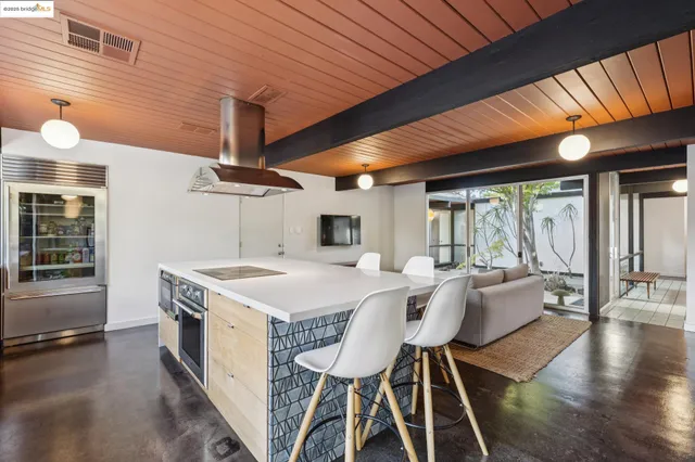 a dining hall with stainless steel appliances granite countertop a sink and cabinets