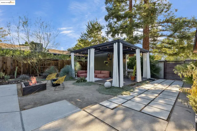 a view of a patio with couches table and chairs with wooden floor and fence