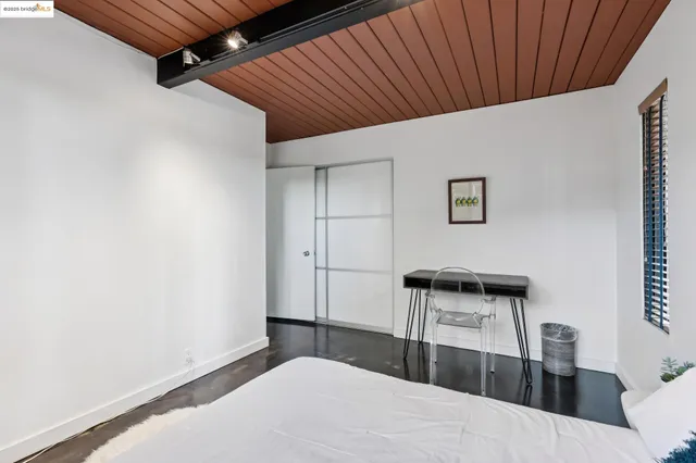 a view of backyard with large tree and wooden fence