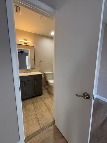 a view of a room with wooden floor and ceiling fan