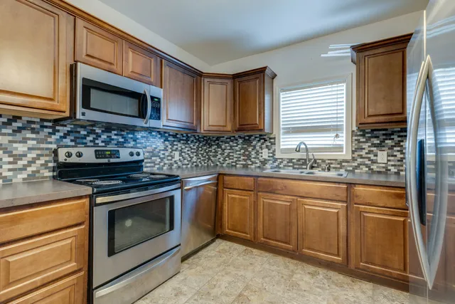 a kitchen with granite countertop cabinets stainless steel appliances and a sink