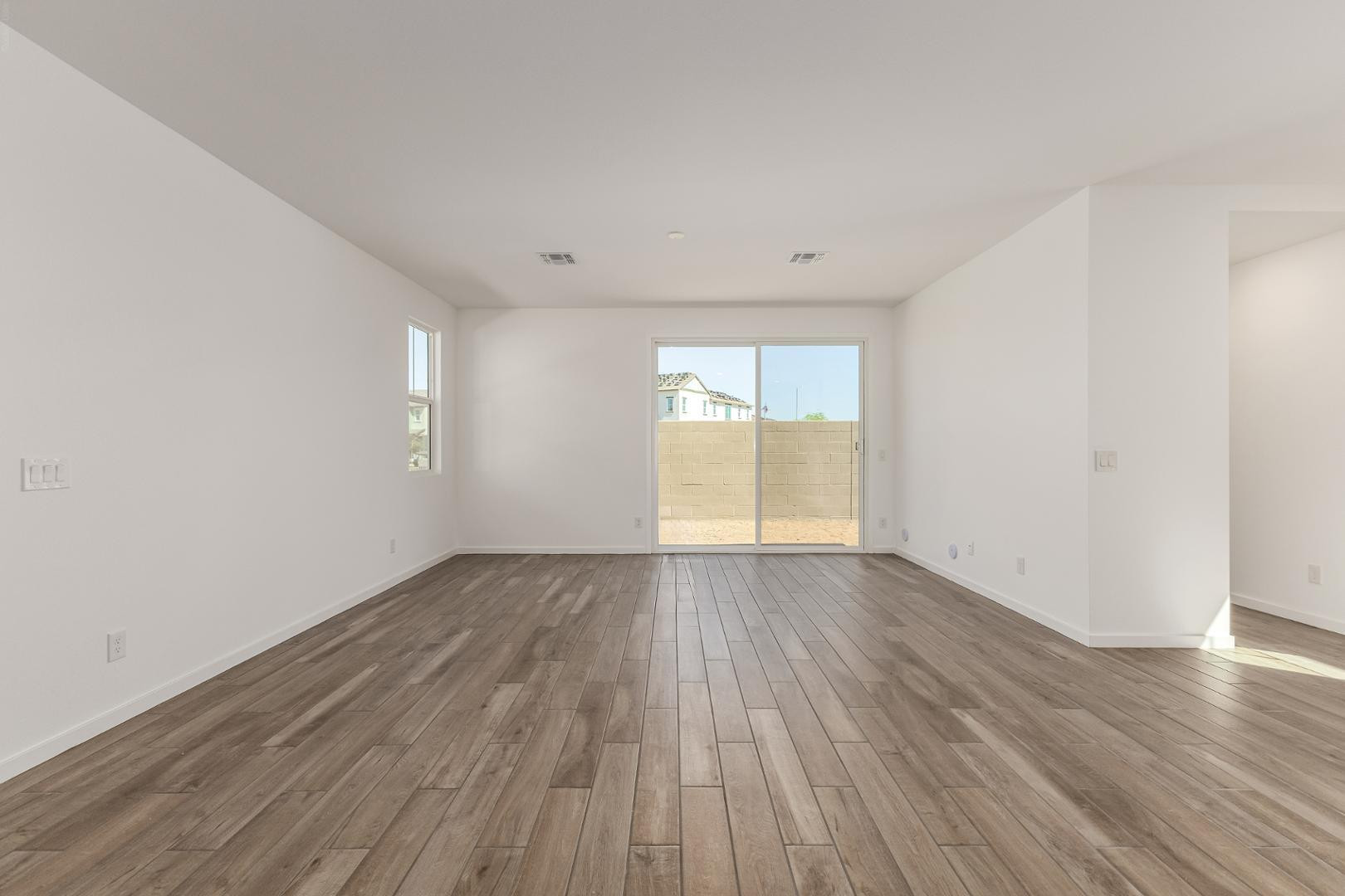 2434 West Maximo Way Phoenix, AZ 85085 - Photo 7 of 35 an empty room with wooden floor and windows