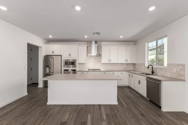 a kitchen with a refrigerator sink and wooden floor