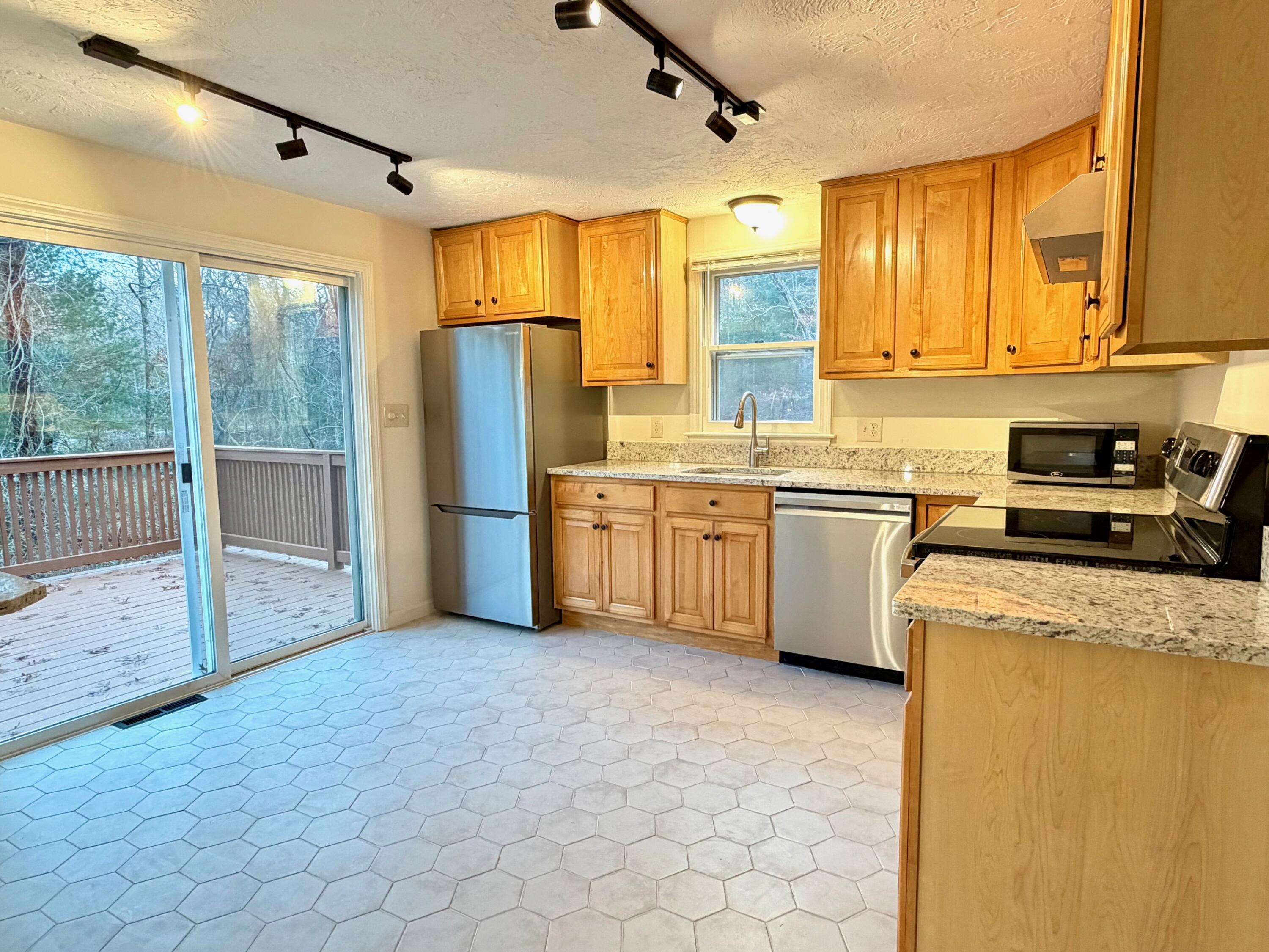 515 Cedar Street West Barnstable, MA 02668 - Photo 14 of 26 a kitchen with stainless steel appliances granite countertop a stove a sink dishwasher a refrigerator and cabinets with wooden floor