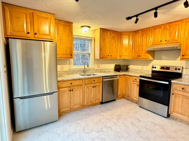 a kitchen with granite countertop stainless steel appliances and refrigerator