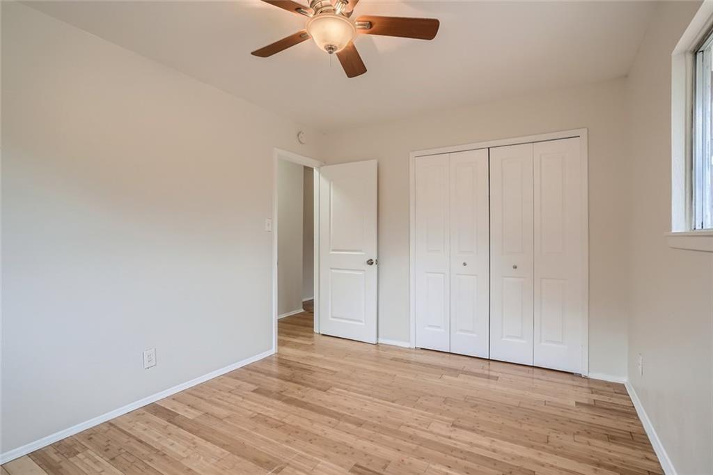 2101 Wheless Lane, Unit A Austin, TX 78723 - Photo 9 of 11 Unfurnished bedroom with light wood-style flooring, a ceiling fan, and a closet