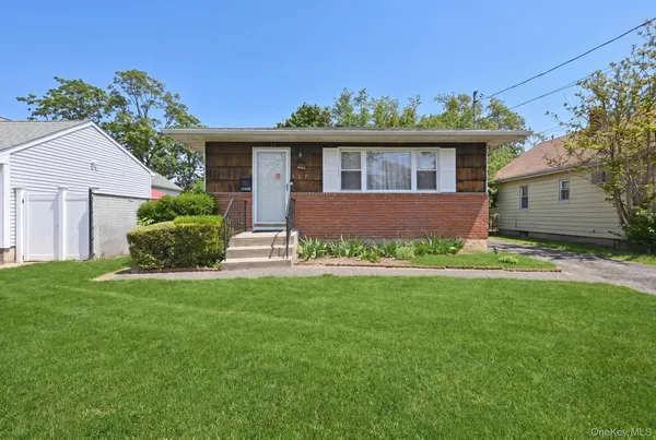 a front view of a house with a garden and yard