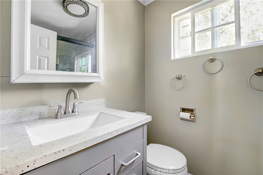 21801 Foley Avenue Carson, CA 90745 - Photo 8 of 10 a bathroom with a granite countertop sink mirror vanity and toilet