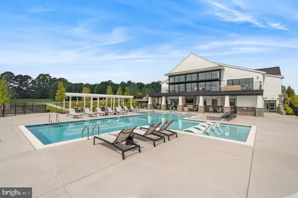 a view of a house with pool and chairs