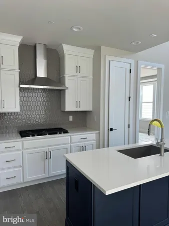 a kitchen with stainless steel appliances granite countertop a sink a stove and cabinets