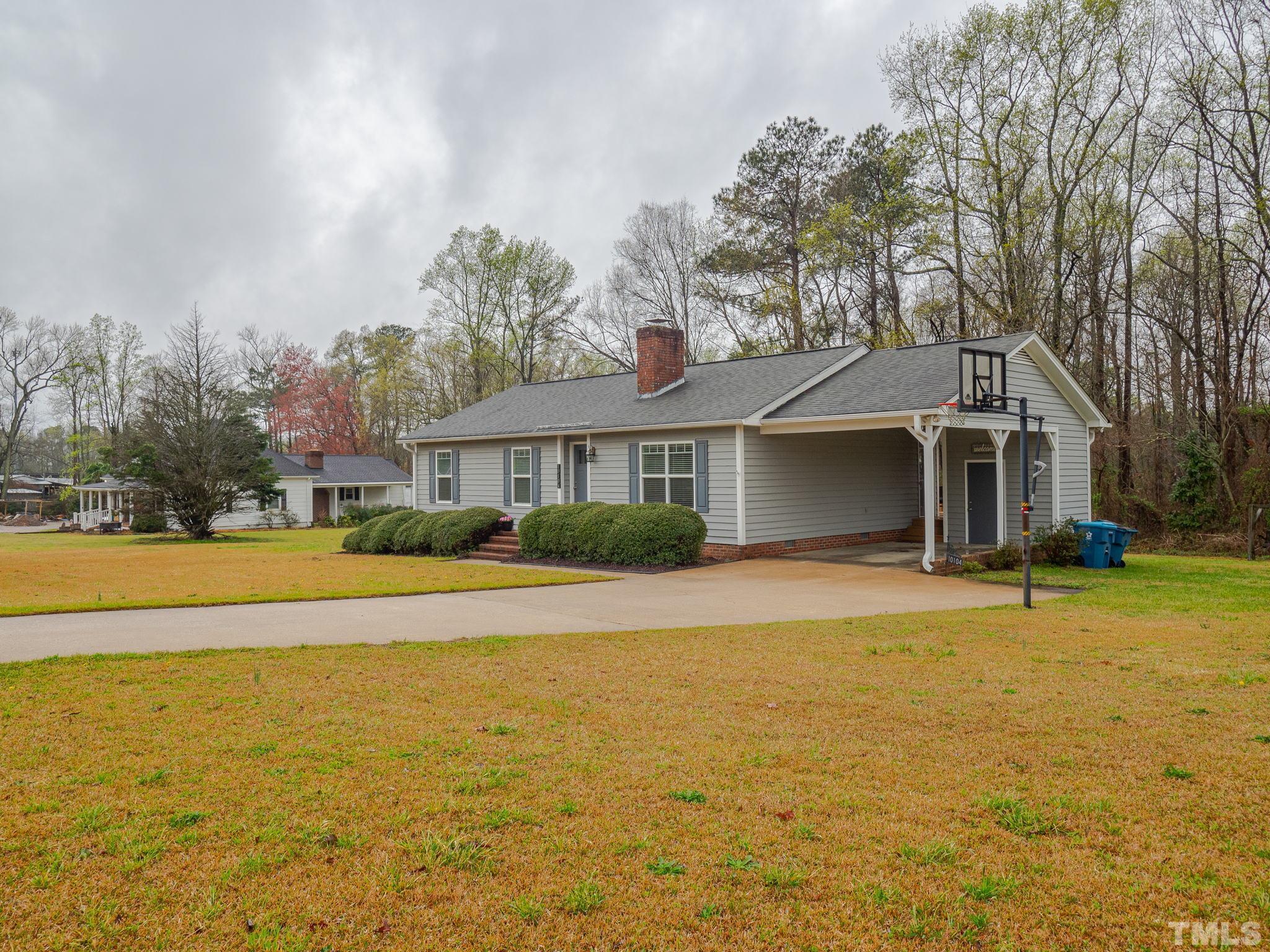 10104 Jordan Road Raleigh, NC 27603 - Photo 2 of 26 a front view of house with swimming pool and yard with trees