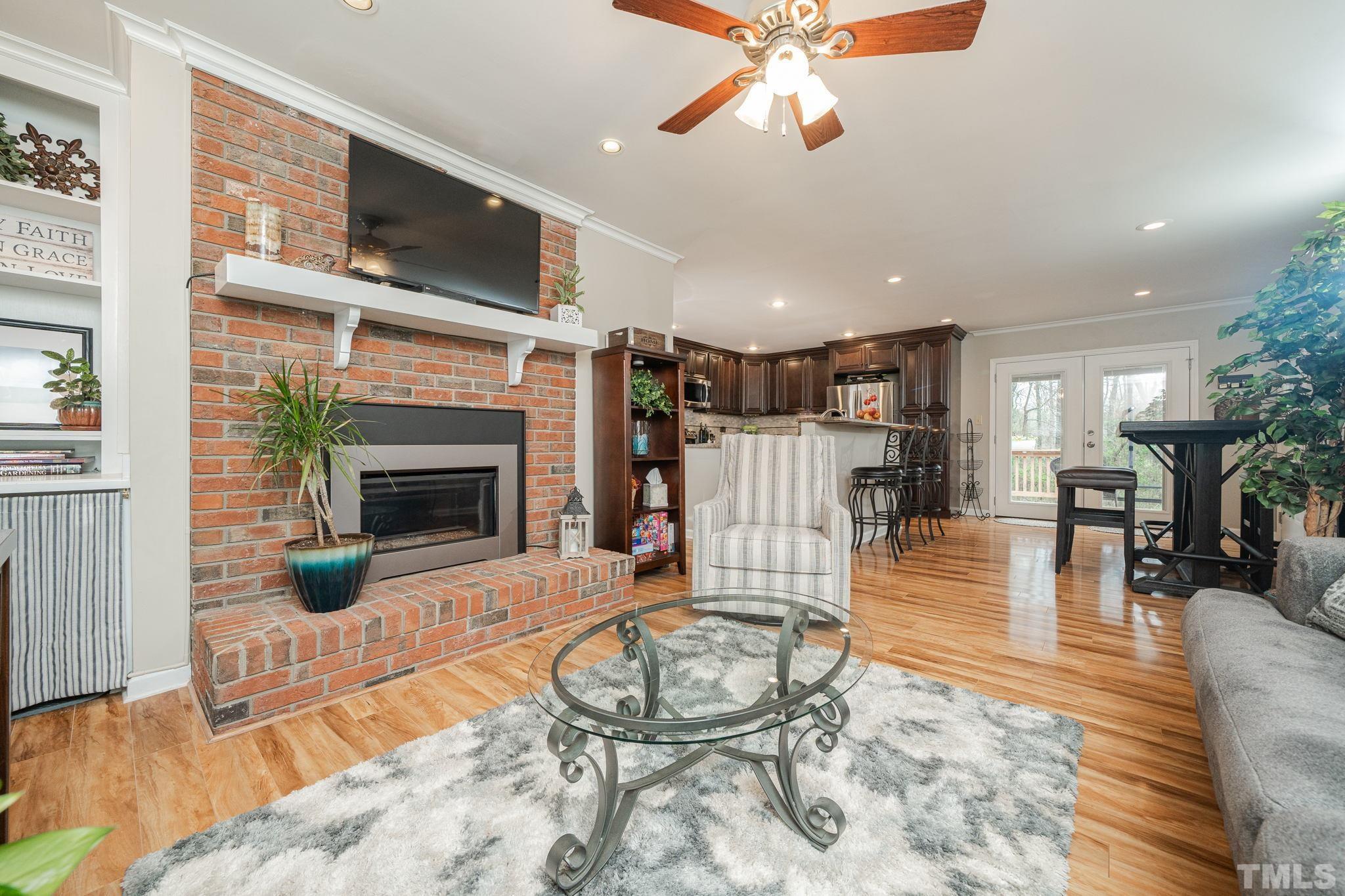 10104 Jordan Road Raleigh, NC 27603 - Photo 24 of 26 a living room with furniture a fireplace and a flat screen tv
