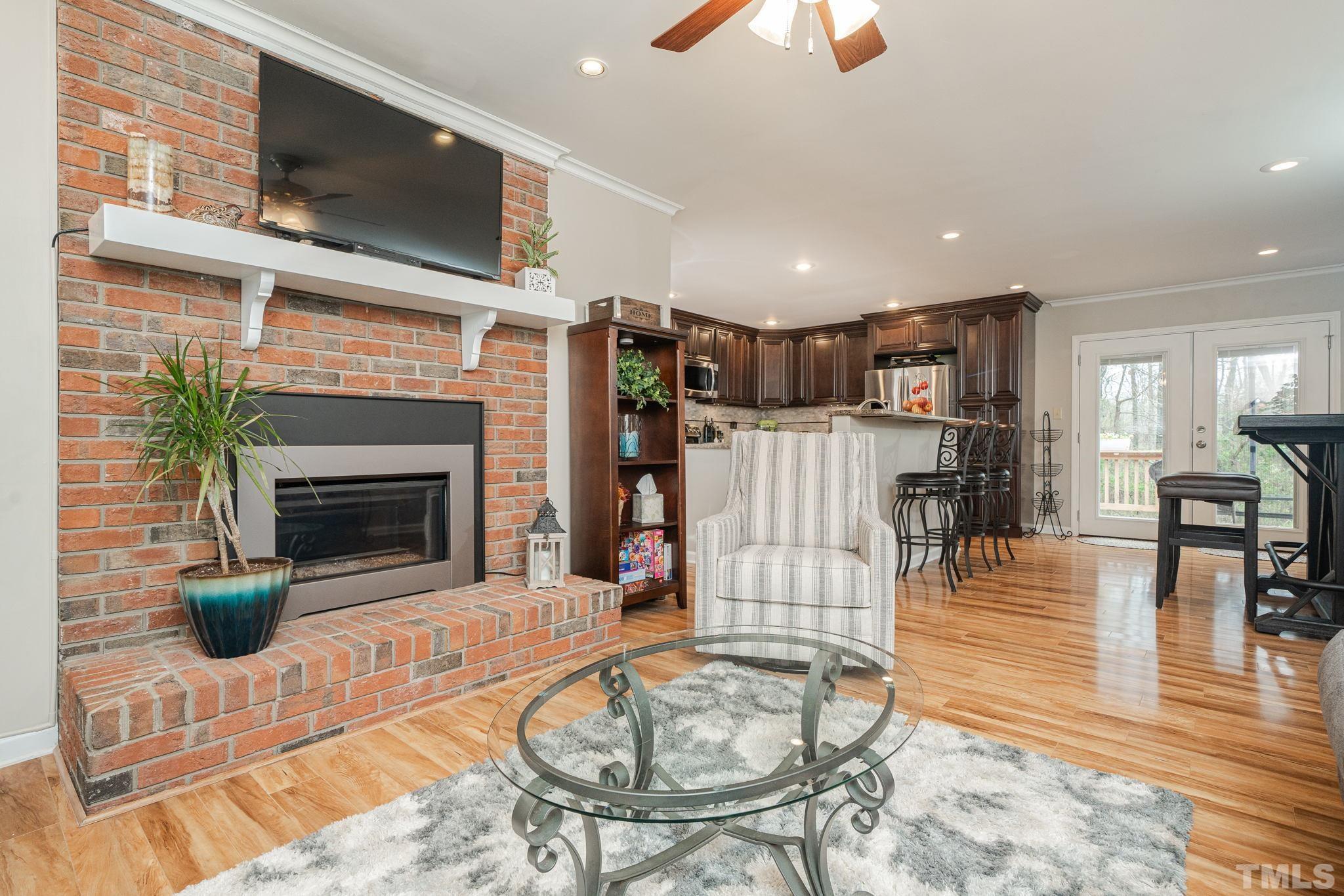 10104 Jordan Road Raleigh, NC 27603 - Photo 25 of 26 a living room with furniture a flat screen tv and a fireplace