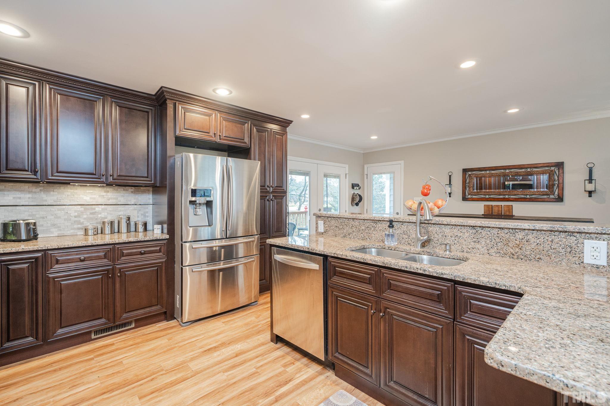 10104 Jordan Road Raleigh, NC 27603 - Photo 9 of 26 a kitchen with stainless steel appliances granite countertop a sink and wooden cabinets