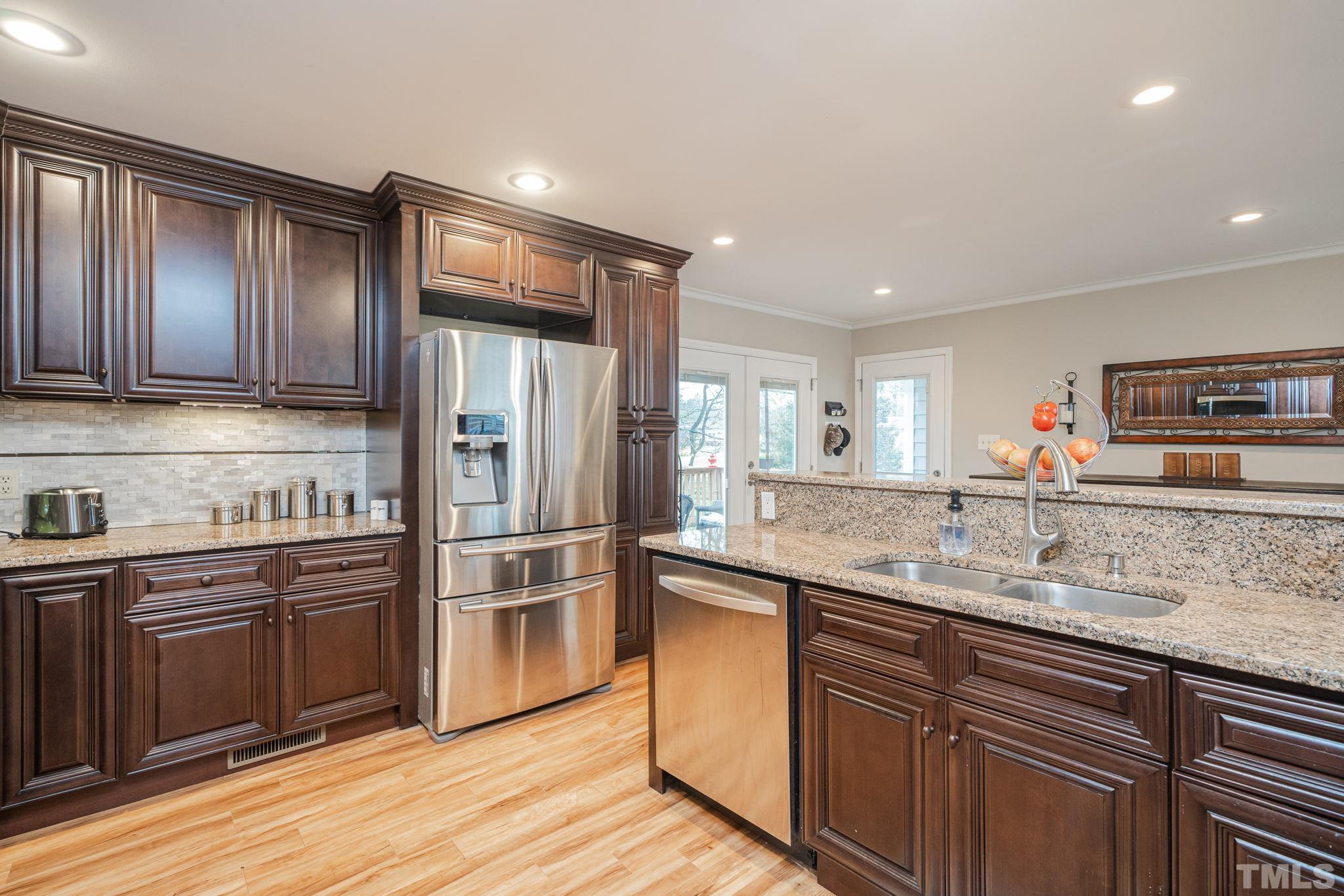 10104 Jordan Road Raleigh, NC 27603 - Photo 10 of 26 a kitchen with stainless steel appliances granite countertop a refrigerator and a stove top oven
