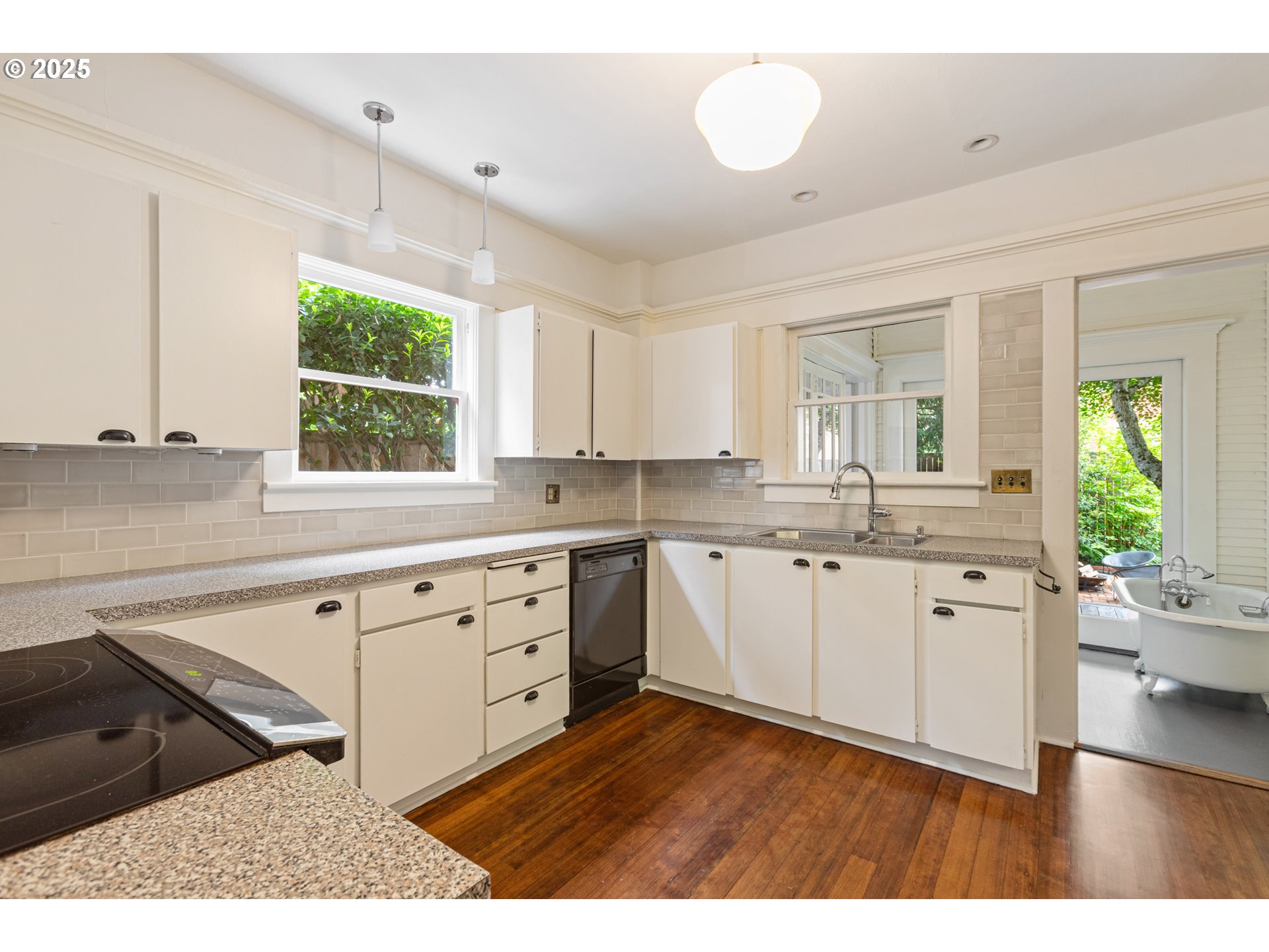 2404 Northeast 47th Avenue Portland, OR 97213 - Photo 15 of 35 a kitchen with white cabinets a sink a window and stainless steel appliances