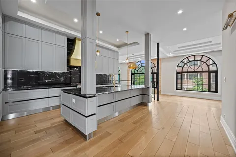 a kitchen with stainless steel appliances granite countertop a stove and a wooden floors