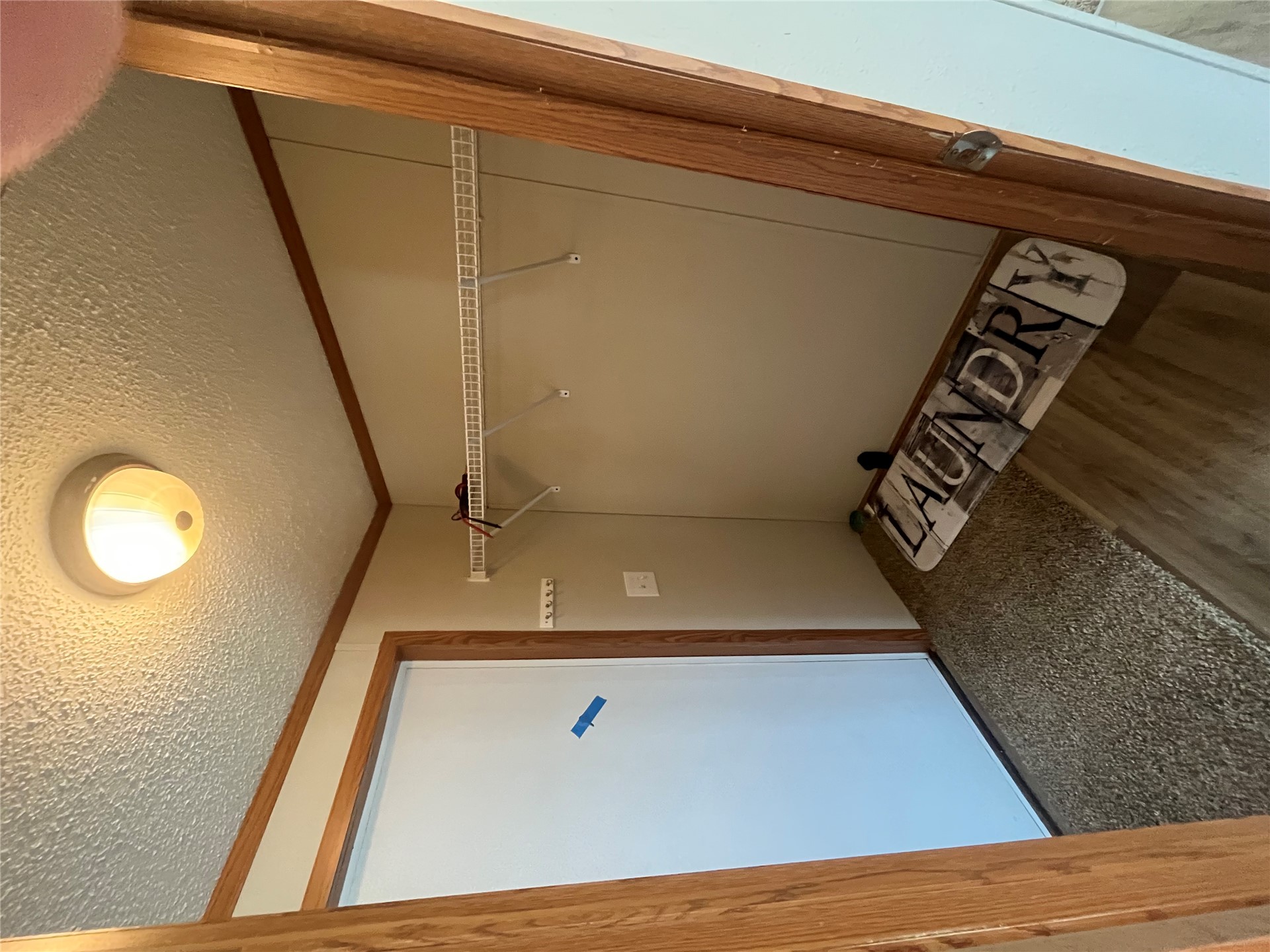 428628 East 1133 Road Porum, OK 74455 - Photo 15 of 16 Recessed laundry area featuring wood-finish flooring, a wire shelving unit, and a built-in ceiling light fixture