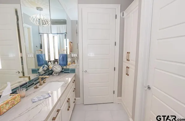 a bathroom with a double vanity sink a mirror and a bathtub
