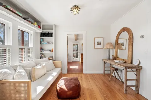 a living room with furniture a wooden floor and a large window