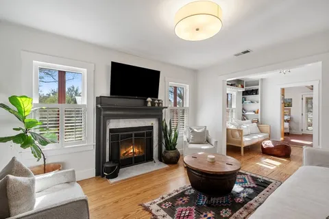a living room with furniture a fireplace and a flat screen tv