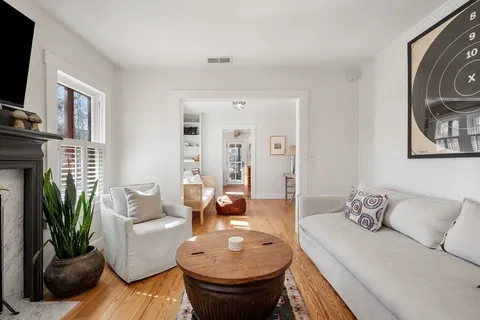 a living room with furniture a fireplace and a flat screen tv