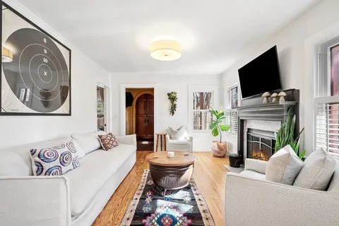 a living room with furniture a flat screen tv and a fireplace