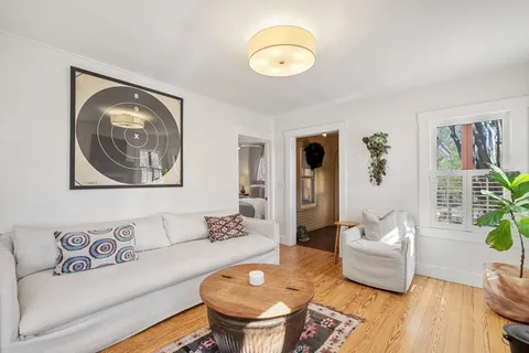 a living room with furniture and a wooden floor