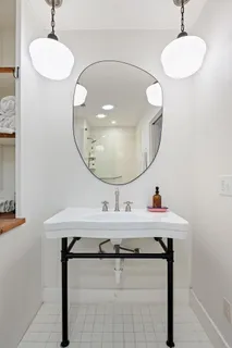 a bathroom with a sink a mirror and a light fixture