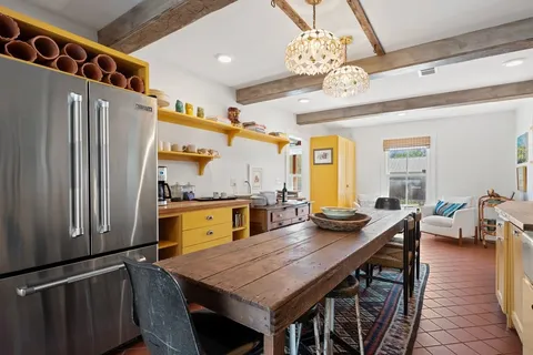 a kitchen with stainless steel appliances granite countertop a stove a refrigerator and a dining table