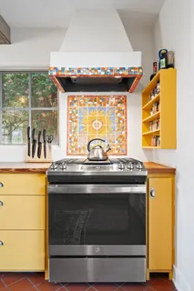 a stove top oven sitting inside of a kitchen
