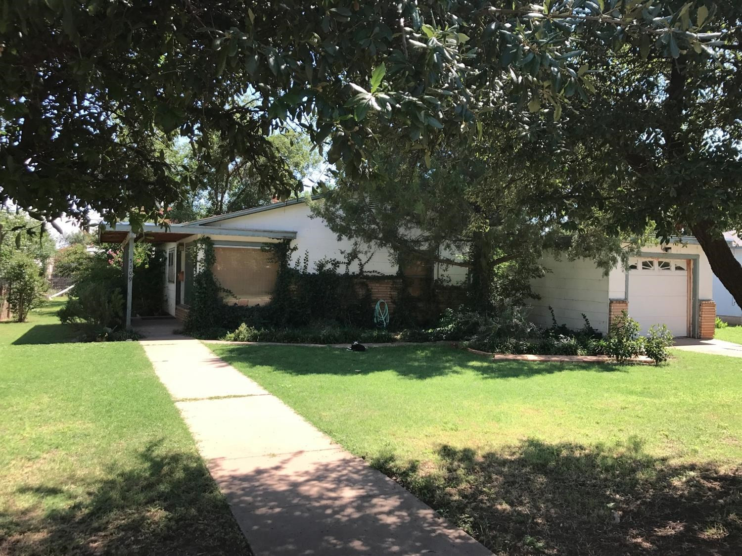 a view of backyard of house with green space