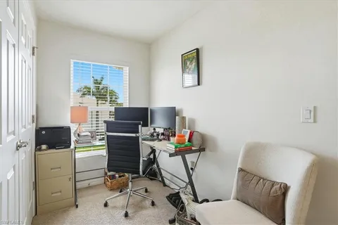 a view of a workspace with furniture and a window
