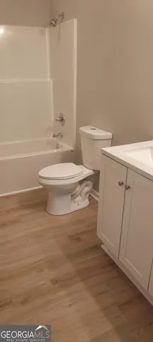a white toilet sitting next to a bathroom sink and a shower