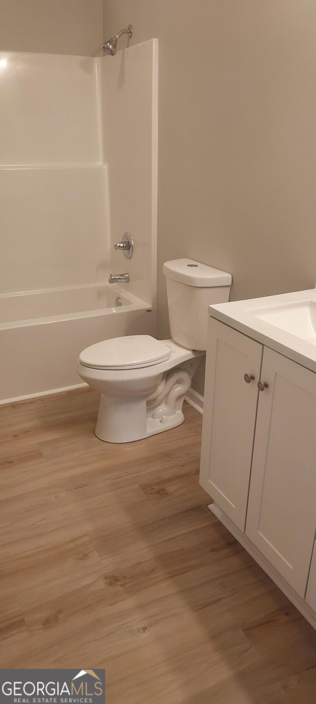 415 Charles Street Bainbridge, GA 39819 - Photo 8 of 9 a white toilet sitting next to a bathroom sink and a shower