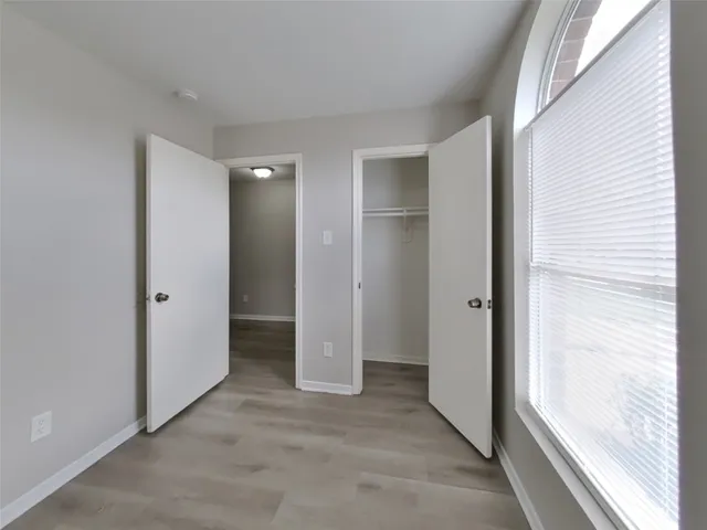 an empty room with closet and windows