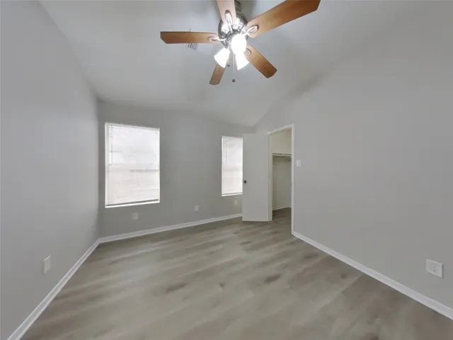 an empty room with fan and windows