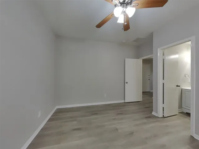 an empty room with closet and a chandelier fan