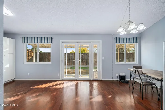 a kitchen with a refrigerator a sink dishwasher a stove and white cabinets with wooden floor