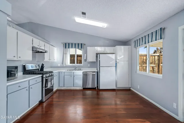a kitchen with a refrigerator stove top oven and sink