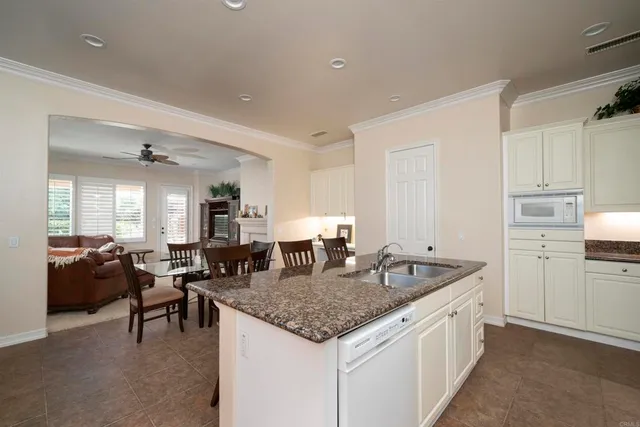 a kitchen with granite countertop kitchen island a sink table and chairs