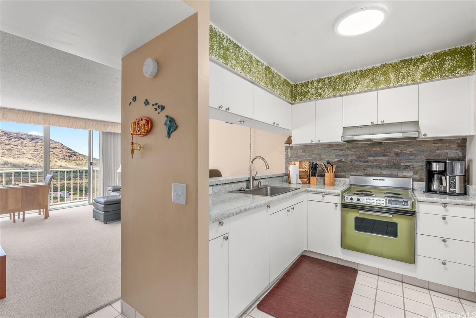 84-680 Kili Drive, Unit C1210 Waianae, HI 96792 - Photo 14 of 24 a kitchen with a sink stove and cabinets