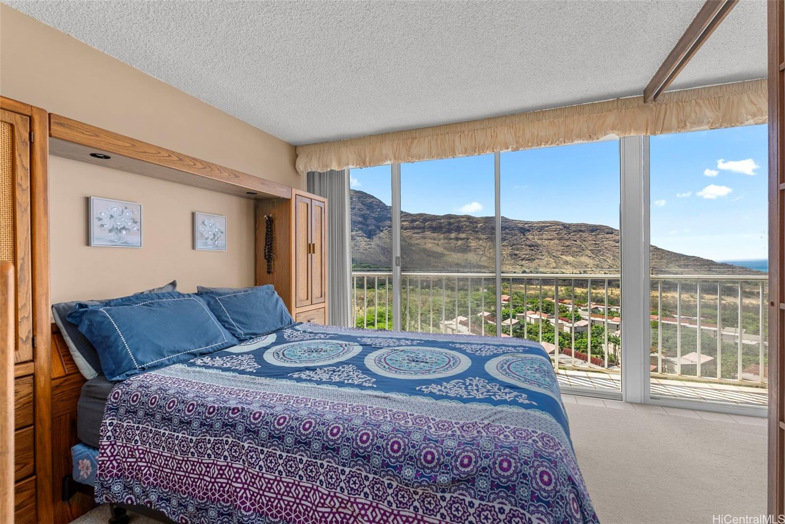 84-680 Kili Drive, Unit C1210 Waianae, HI 96792 - Photo 10 of 24 a bed sitting in a bedroom next to a window