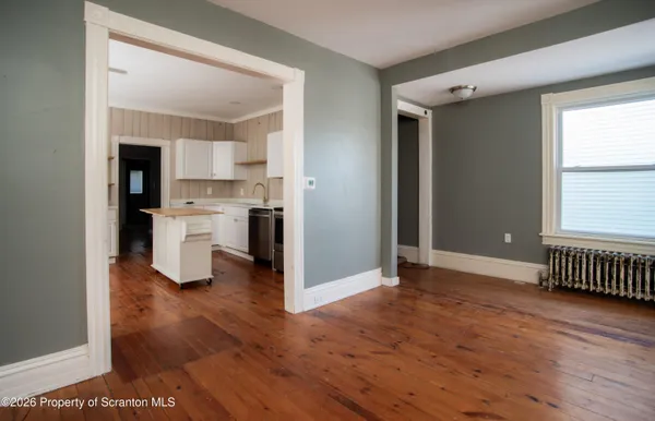 a view of a kitchen with wooden floor and a sink