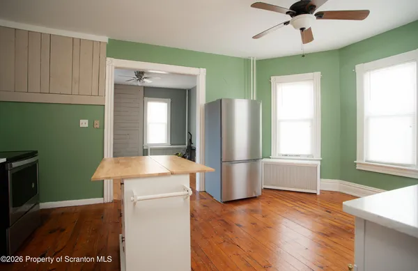 a room with stainless steel appliances wooden floor and chandelier